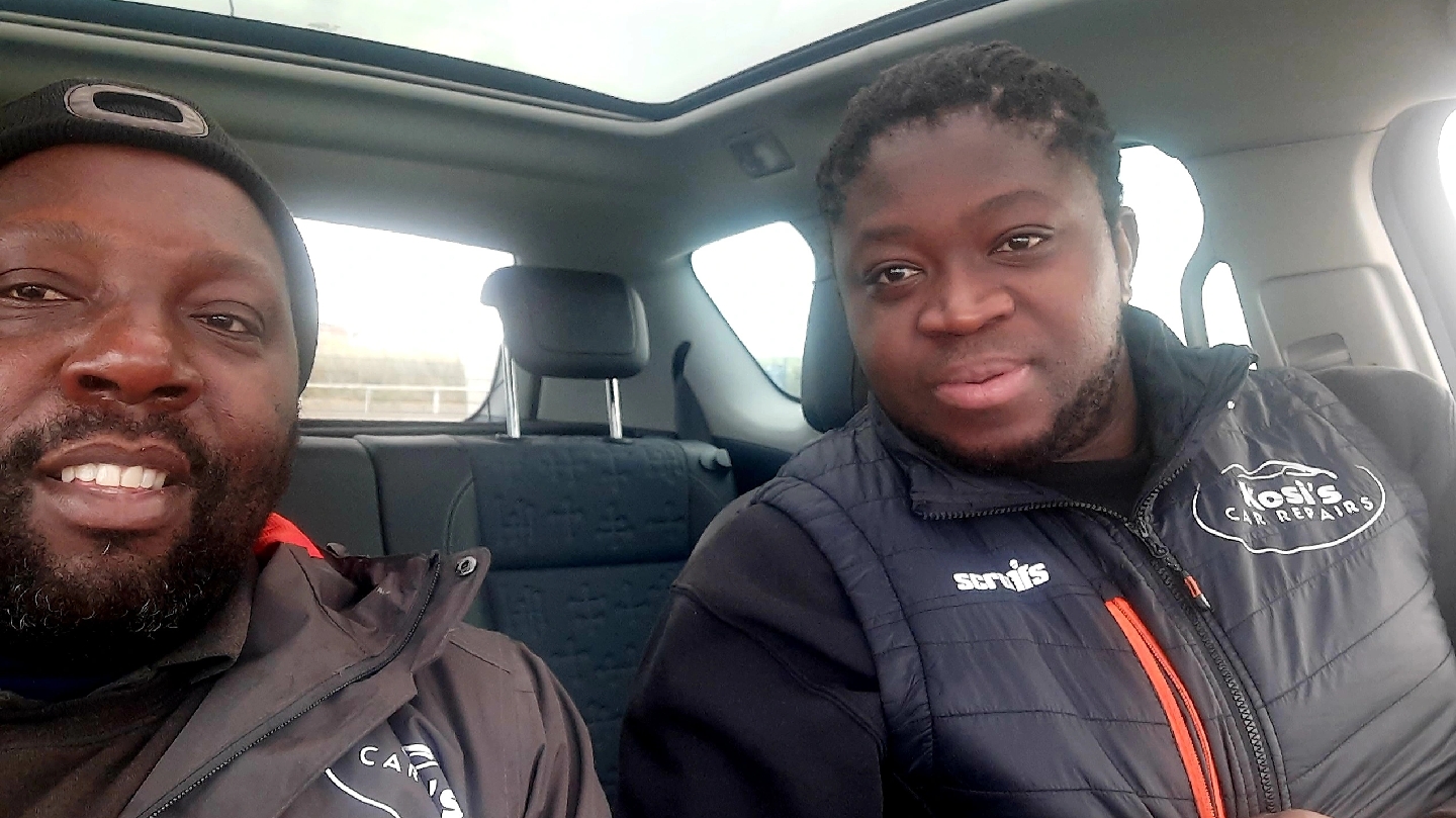 Two members of the Kosi's Car Repairs team in branded jackets